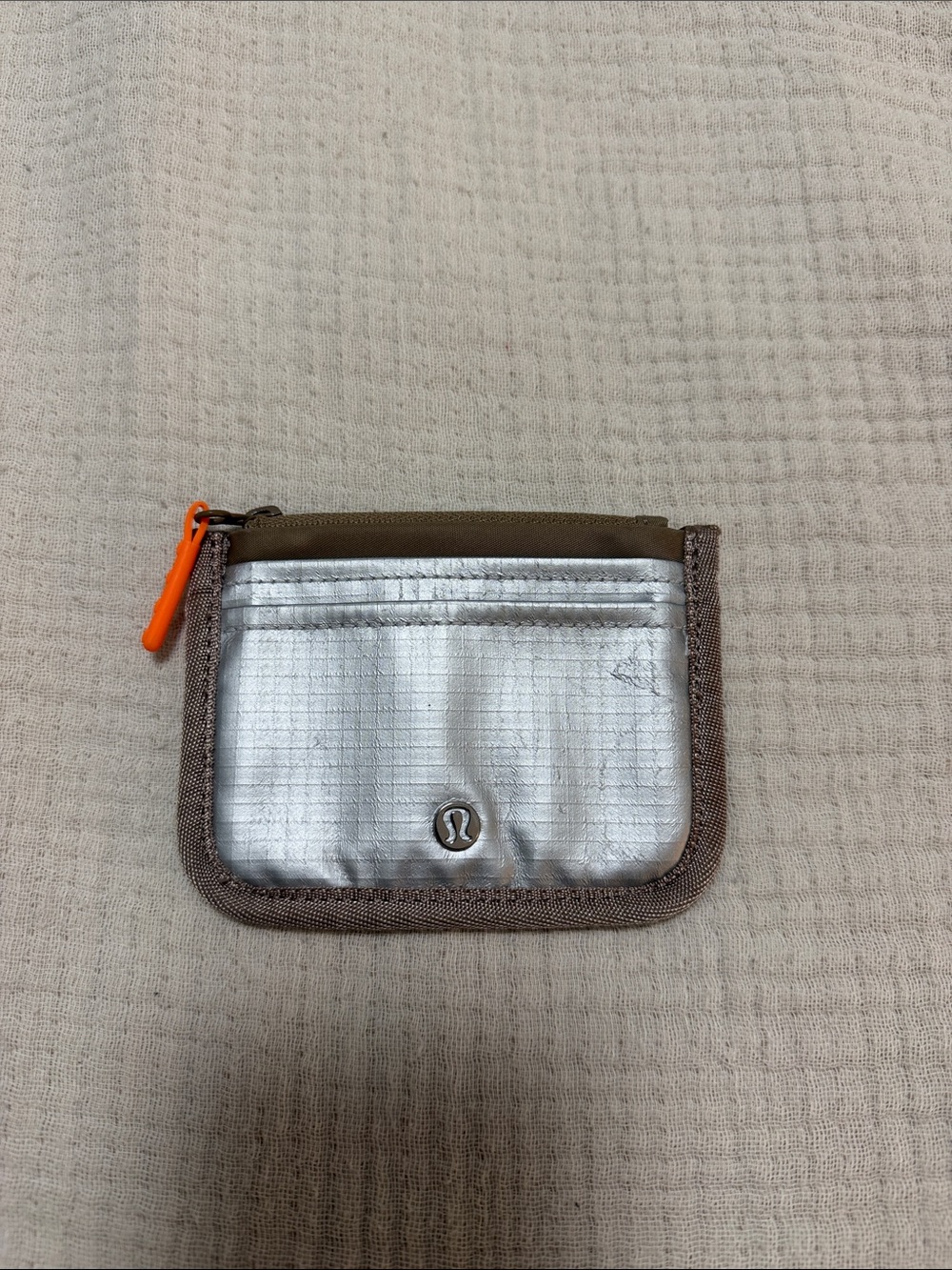 lululemon athletica silver metallic card pouch with brown trim and orange pull